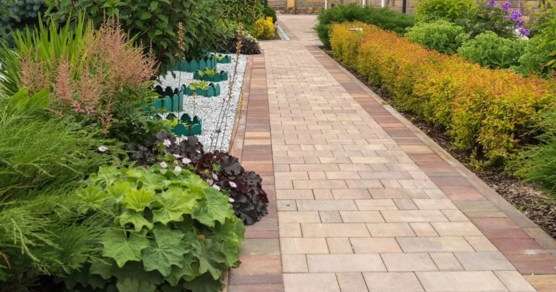 Прямолинейная широкая дорожка из тротуарной плитки Браер в саду классического стиля