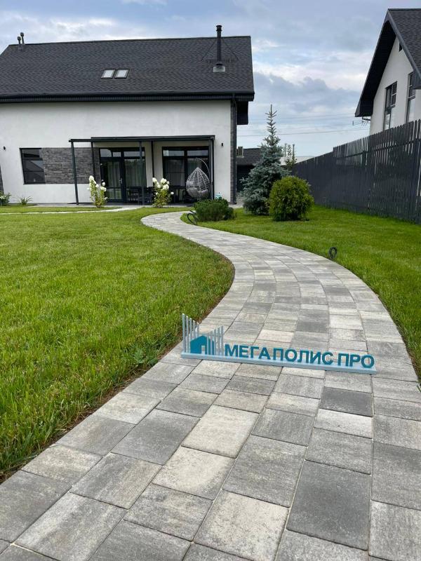 Дом в черно-белой цветовой гамме в сочетании с тротуарной плиткой серых оттенков